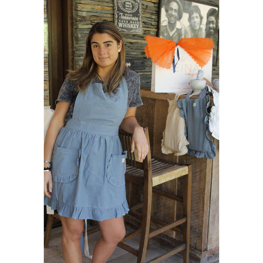 Delantal azul con vuelos en su bolsita